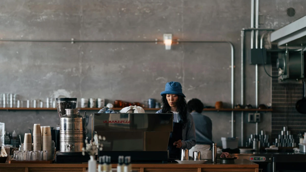 Papacko coffee shop counter with barista preparing drinks using custom branded paper cups