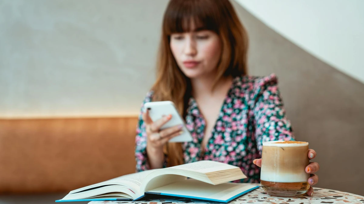 Papacko customer scanning QR code on coffee cup with smartphone in modern café setting