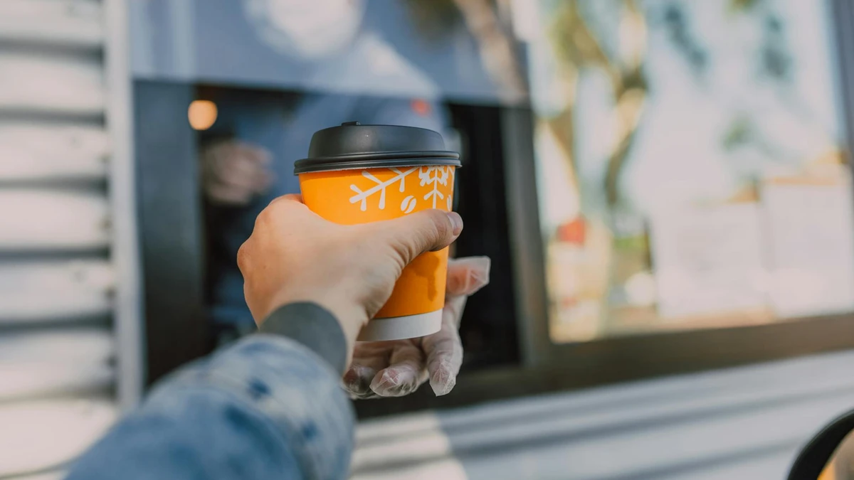 Drive-thru café service using sustainable cup holders for beverage delivery