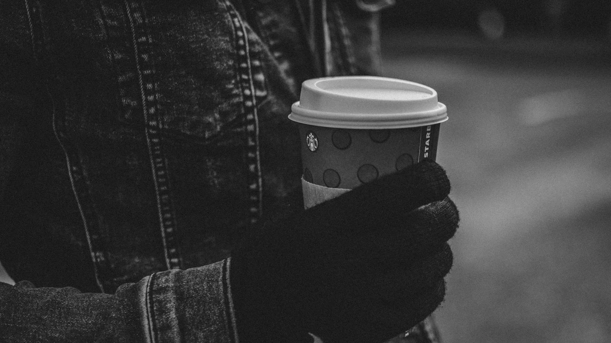 Papacko customer drinking coffee from takeaway cup with quality lid in urban outdoor setting