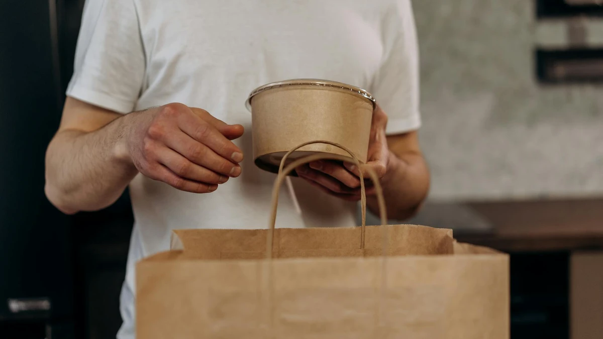 Papacko food delivery driver organizing takeaway orders in biodegradable trays and compostable containers in