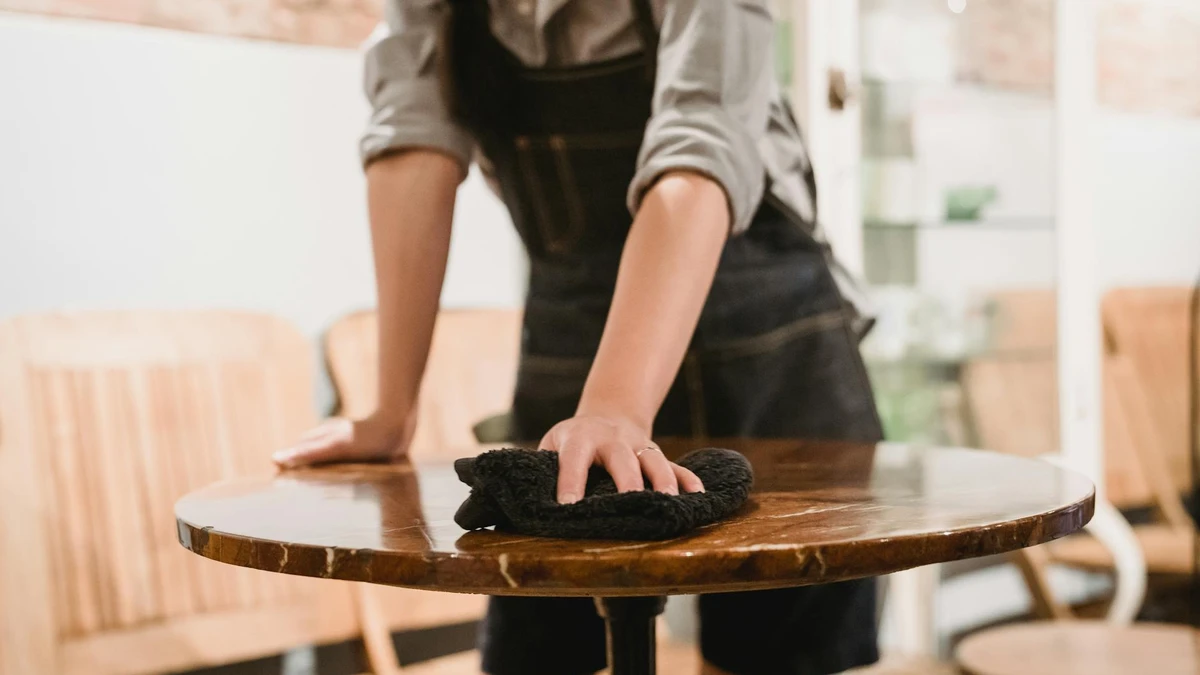 Restaurant staff setting table with embossed branded napkins - Papacko hospitality packaging