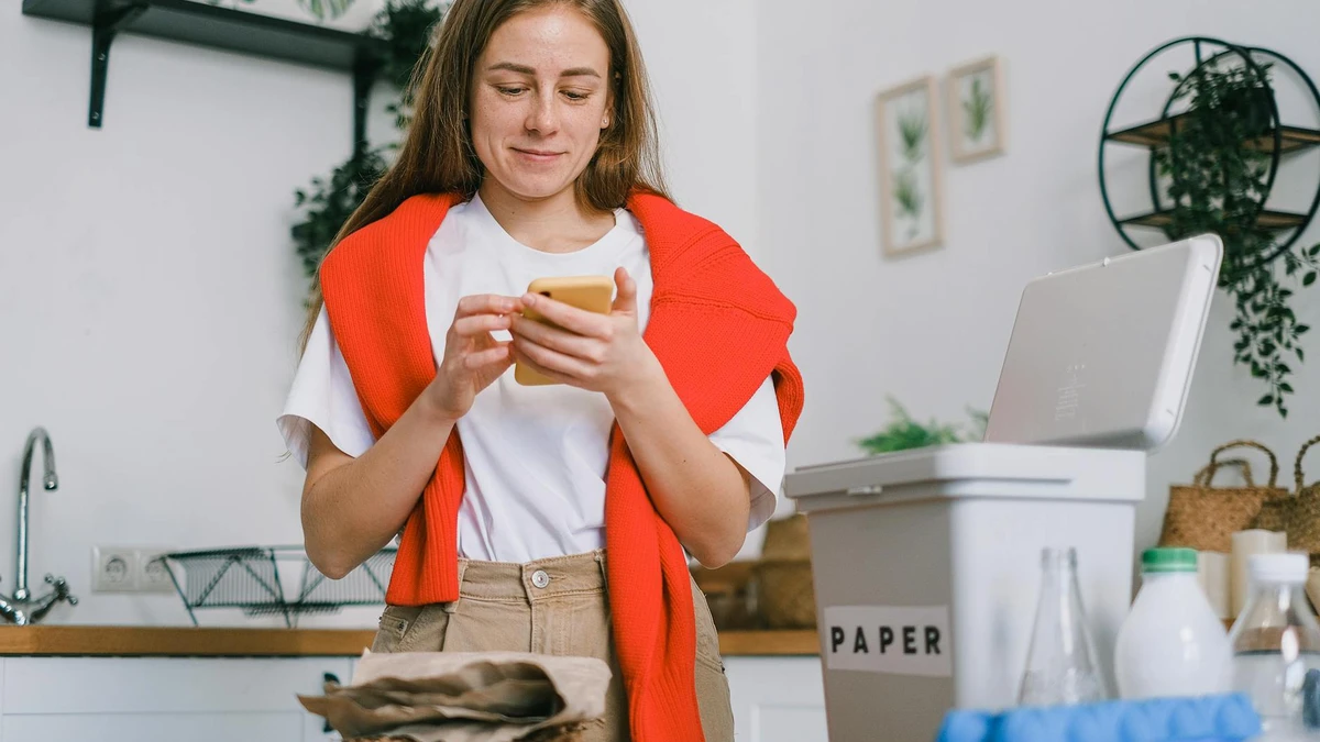 Papacko café customer recycling paper cup in clearly marked recycling bin with sustainability signage