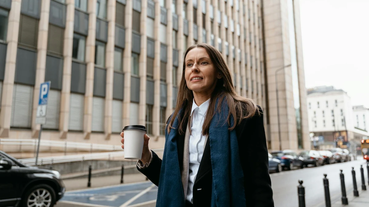 Papacko customer holding branded coffee cup while walking in urban environment, showing mobile marketing eff