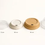 Five paper cup lids arranged by rim diameter from 62 mm to 104 mm on white background