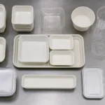Empty unbranded airline meal packaging components arranged on a neutral catering preparation surface