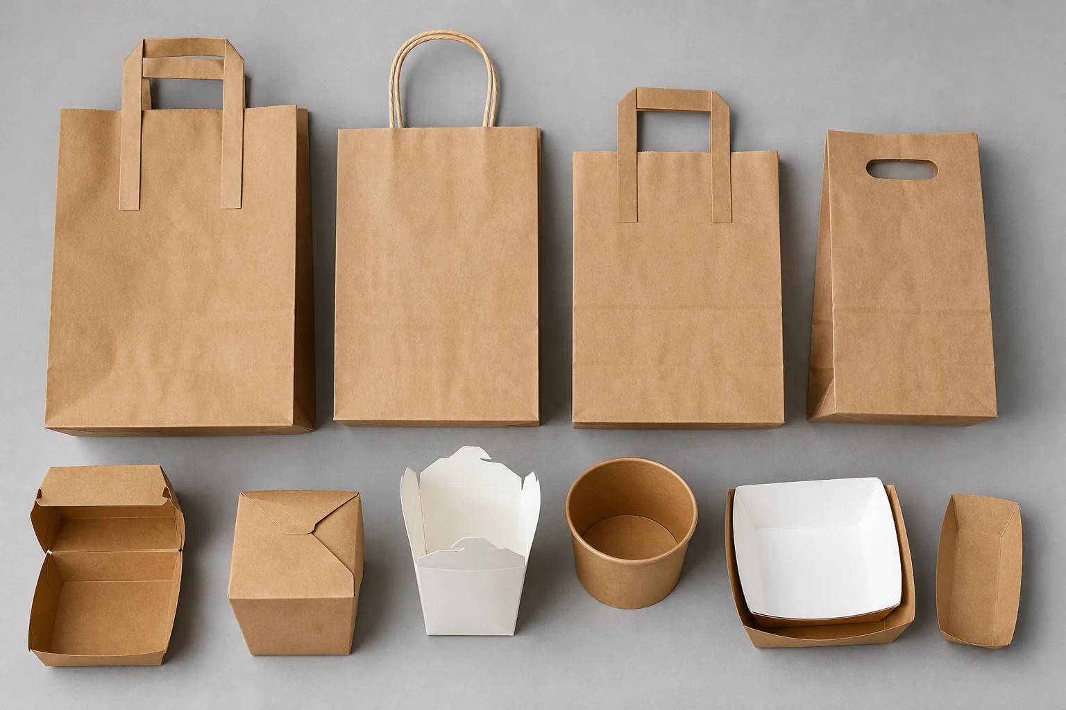 Empty unbranded paper bags with different handle styles arranged for specification review
