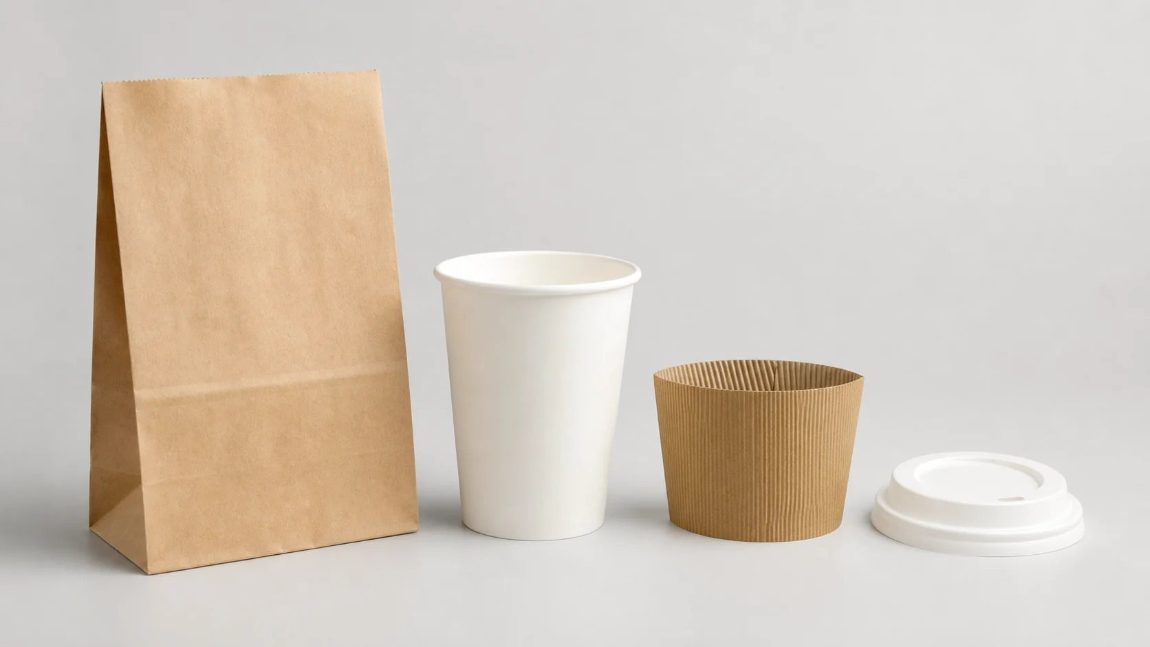 Empty unbranded container cup lid sleeve and bag arranged as separate packaging components